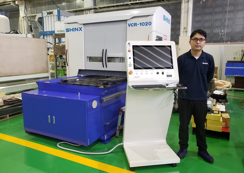 シンクス株式会社様の開先機械と門奈氏（アドライズがカバーのデザインと設計を担当）